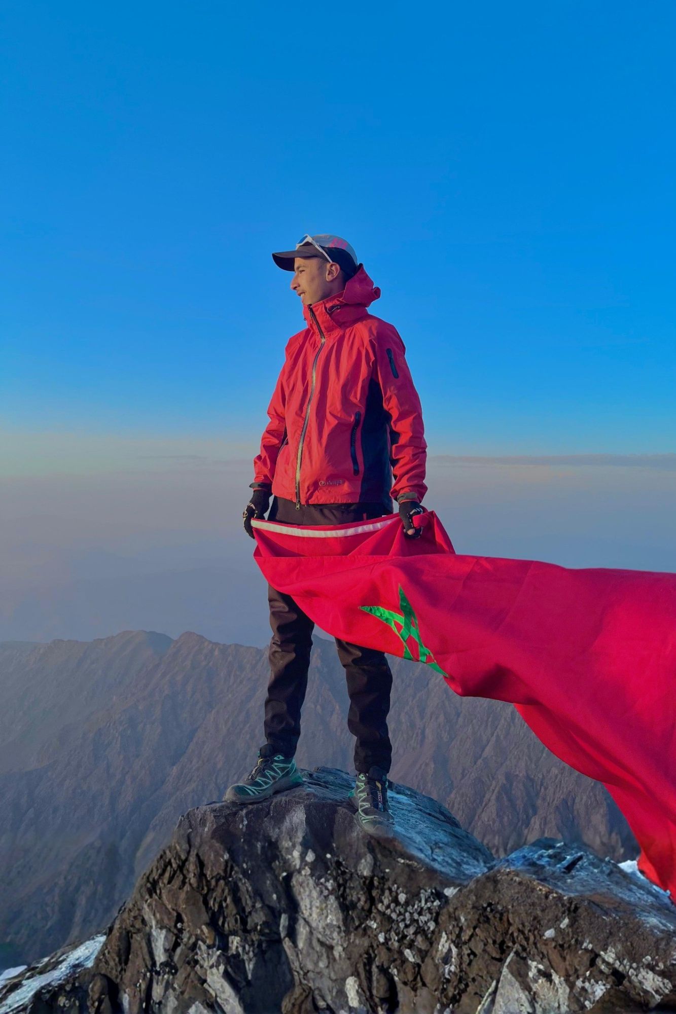 Mouad Maskouk, licensed Imlil guide, on Mount Toubkal summit at sunrise